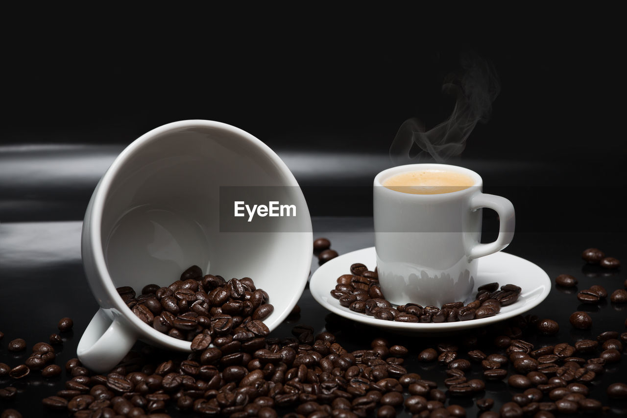 Close-up of coffee cup and coffee beans on table