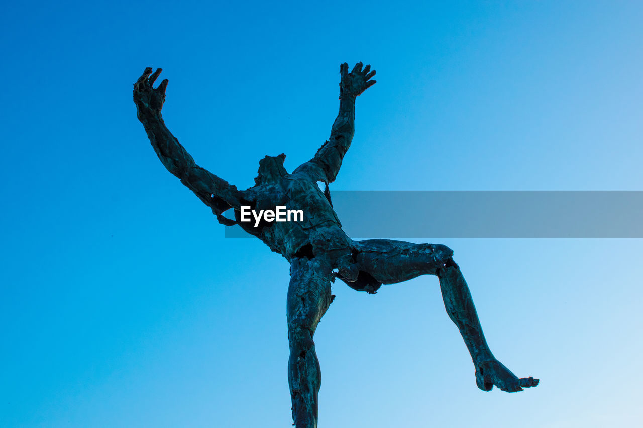 LOW ANGLE VIEW OF STATUE AGAINST BLUE SKY