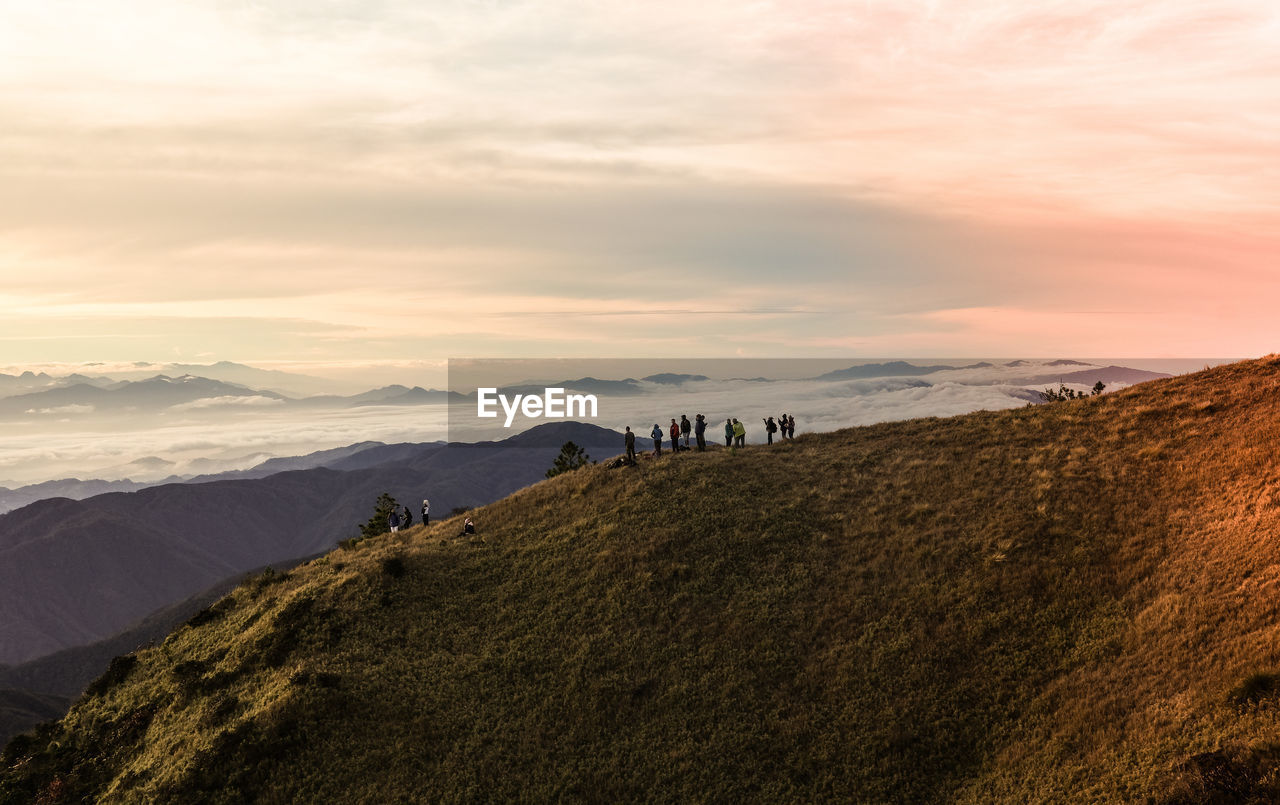 High angle view of people standing on mountain against sky