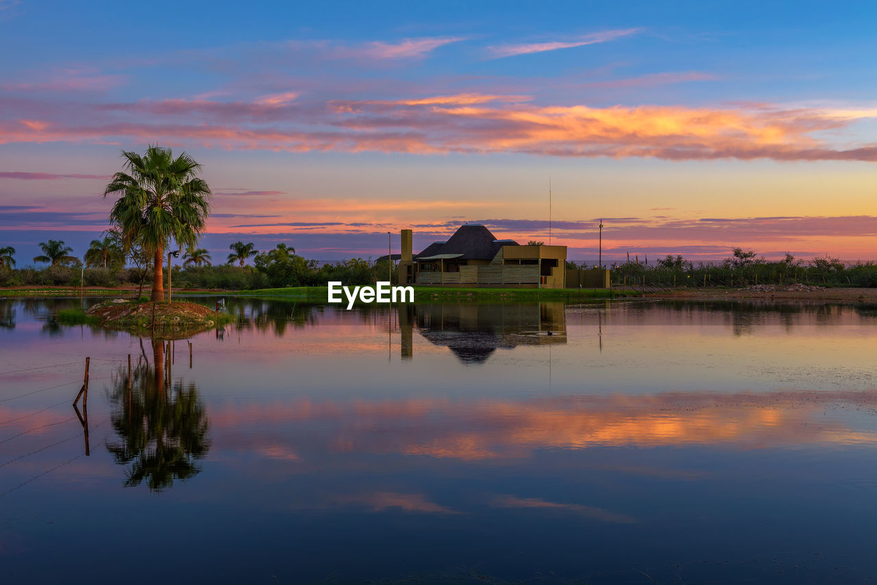 SCENIC VIEW OF LAKE BY BUILDING AGAINST SKY