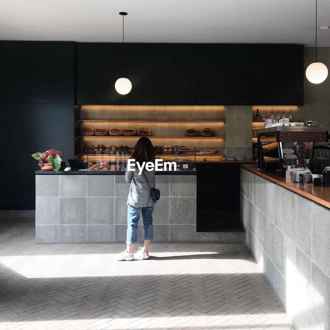 Rear view of woman standing in cafe