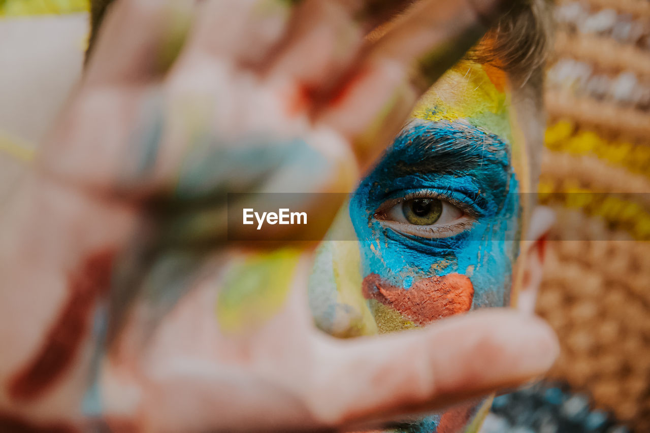 Close-up of boy with face paint gesturing outdoors