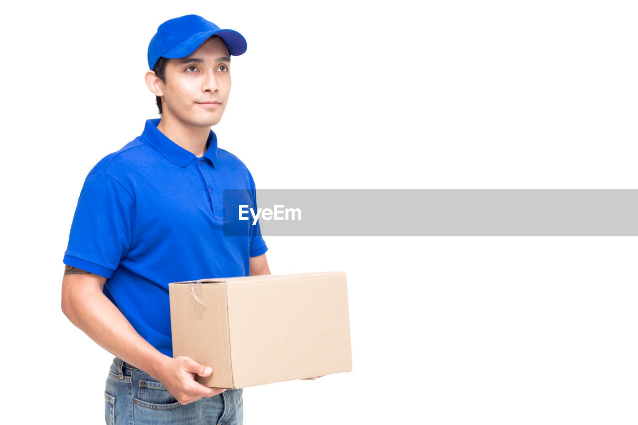 Salesman with cardboard box standing against white background