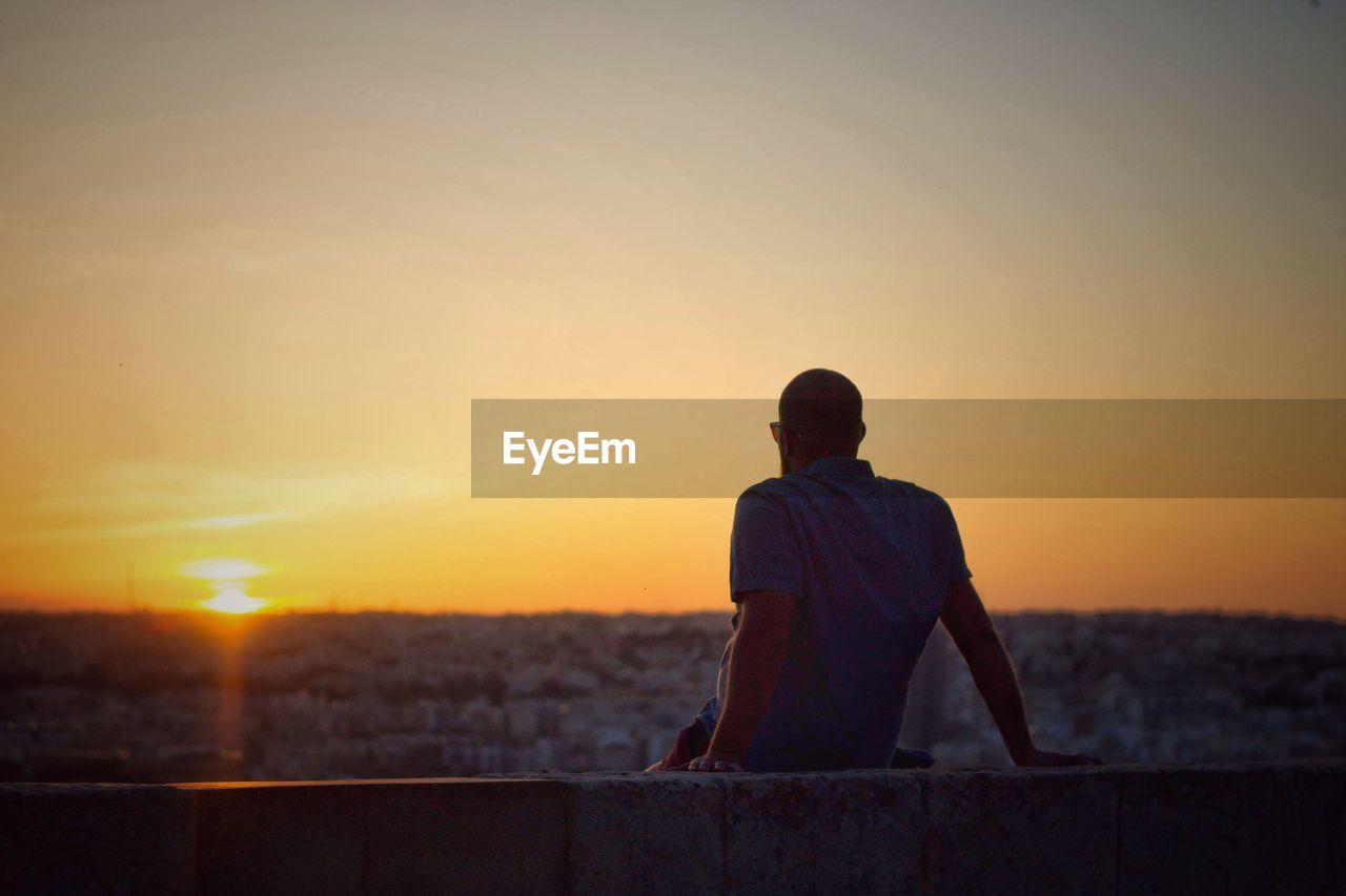 Rear view of man looking at sunset