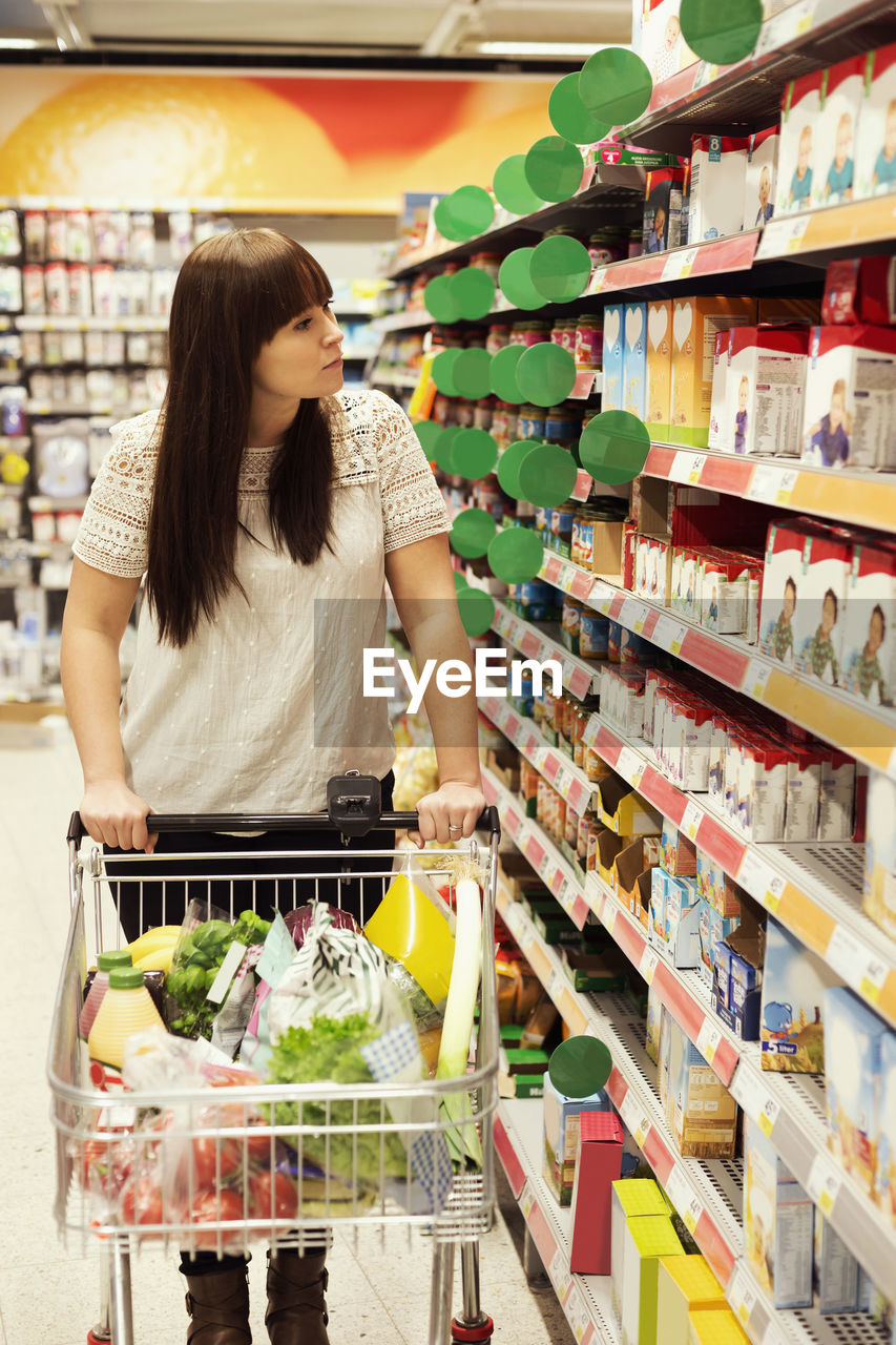 Woman looking at products while shopping in supermarket