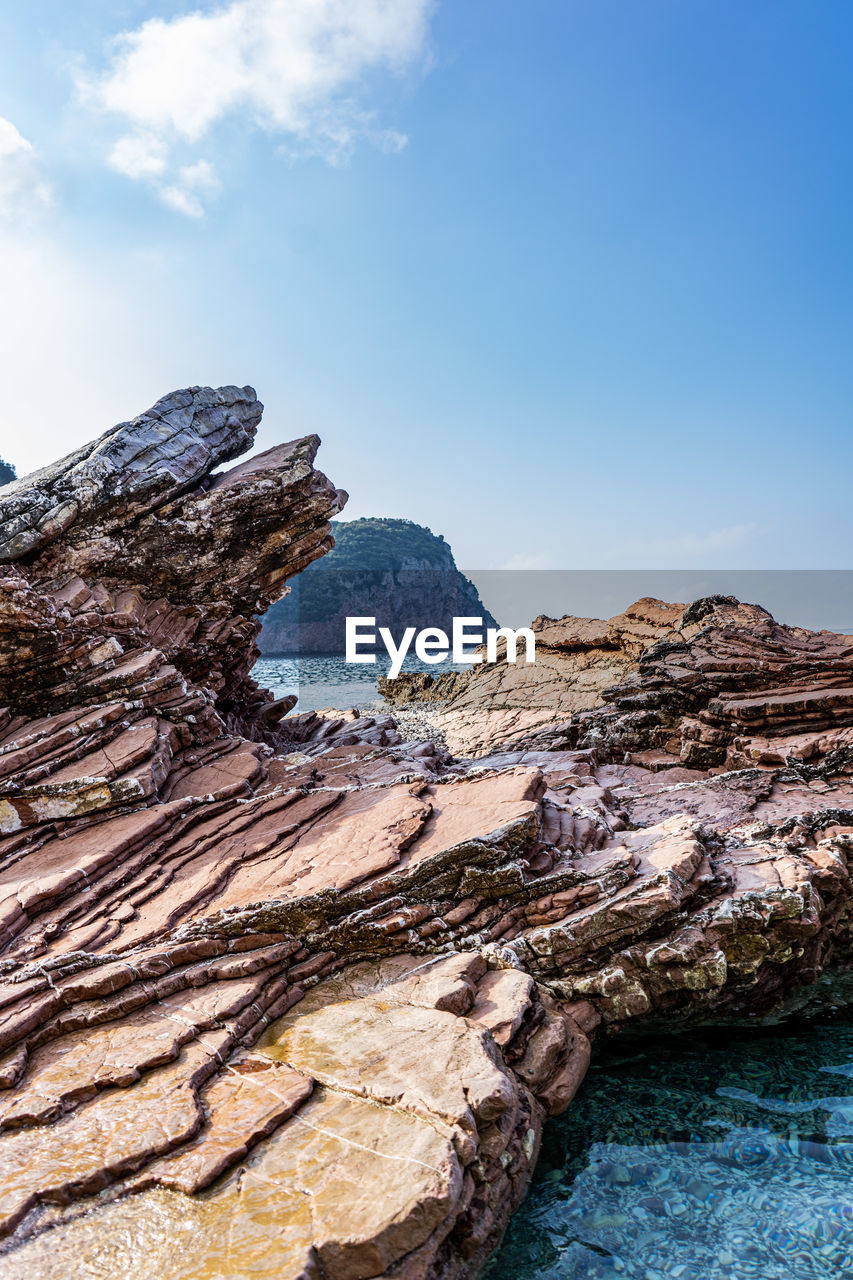 Rock formations by sea against sky