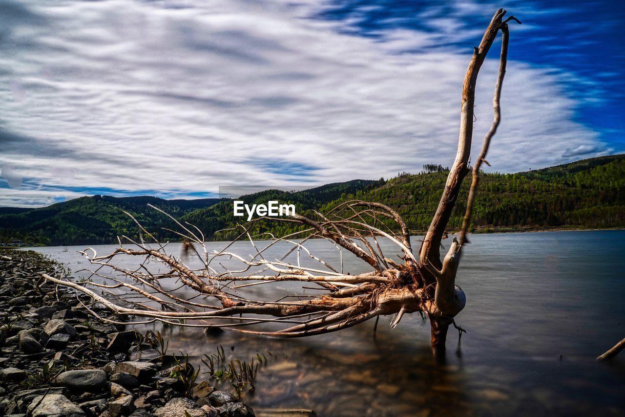 Scenic view of lake by mountain against sky