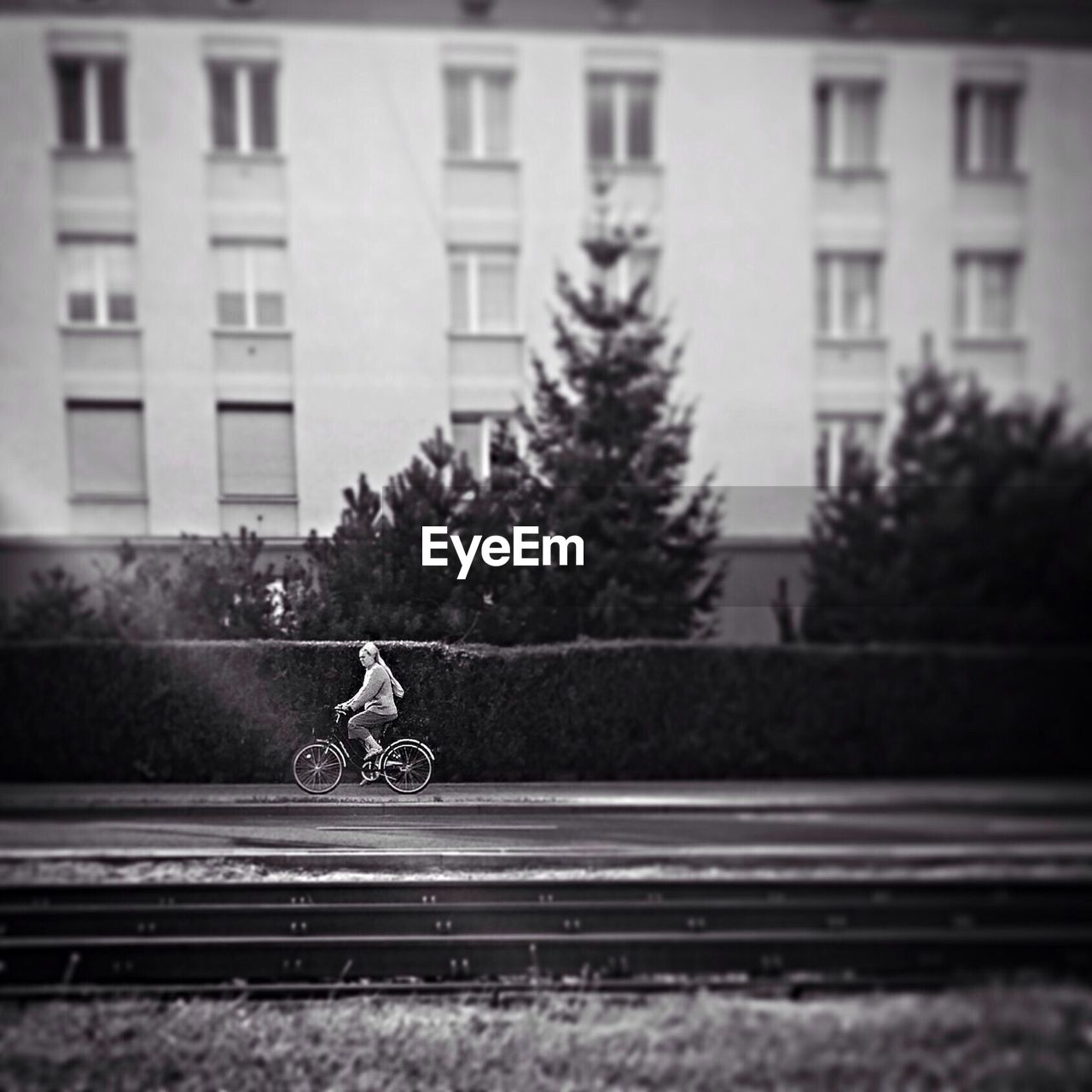 Woman on bicycle by buildings in city