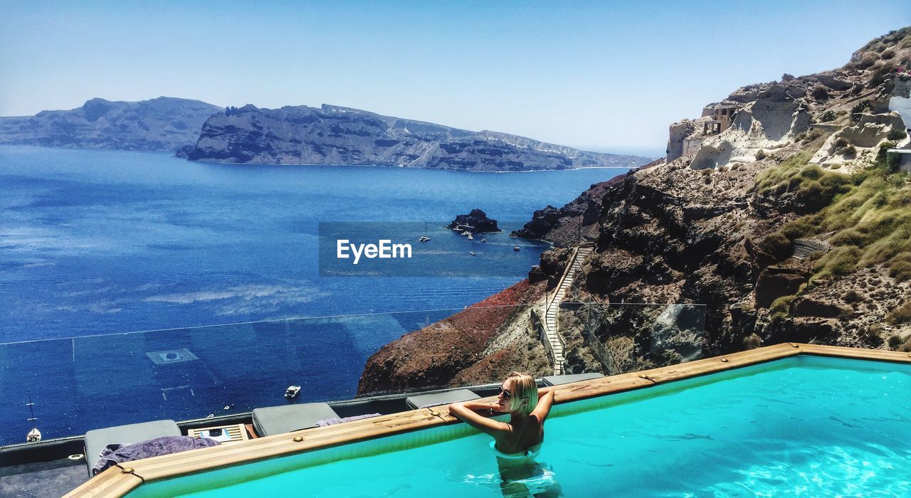 Woman on swimming pool against sea