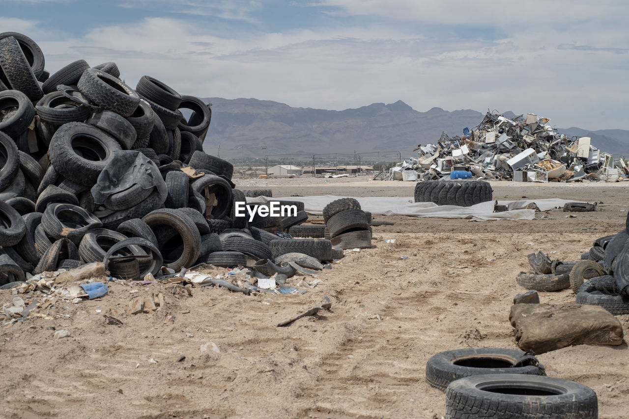 Piles of worn out tires in mojave desert landscape with mountain range in background