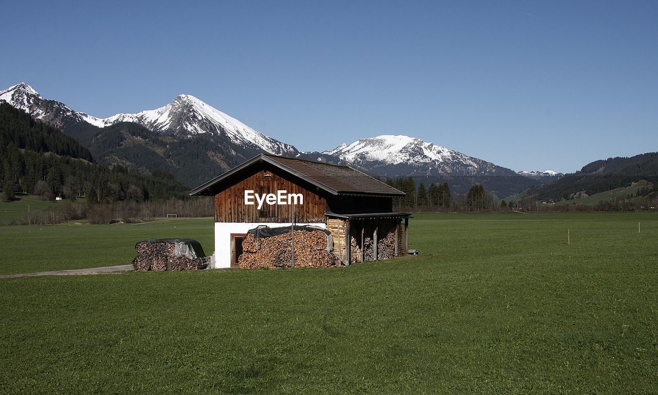 HOUSE ON FIELD AGAINST SKY