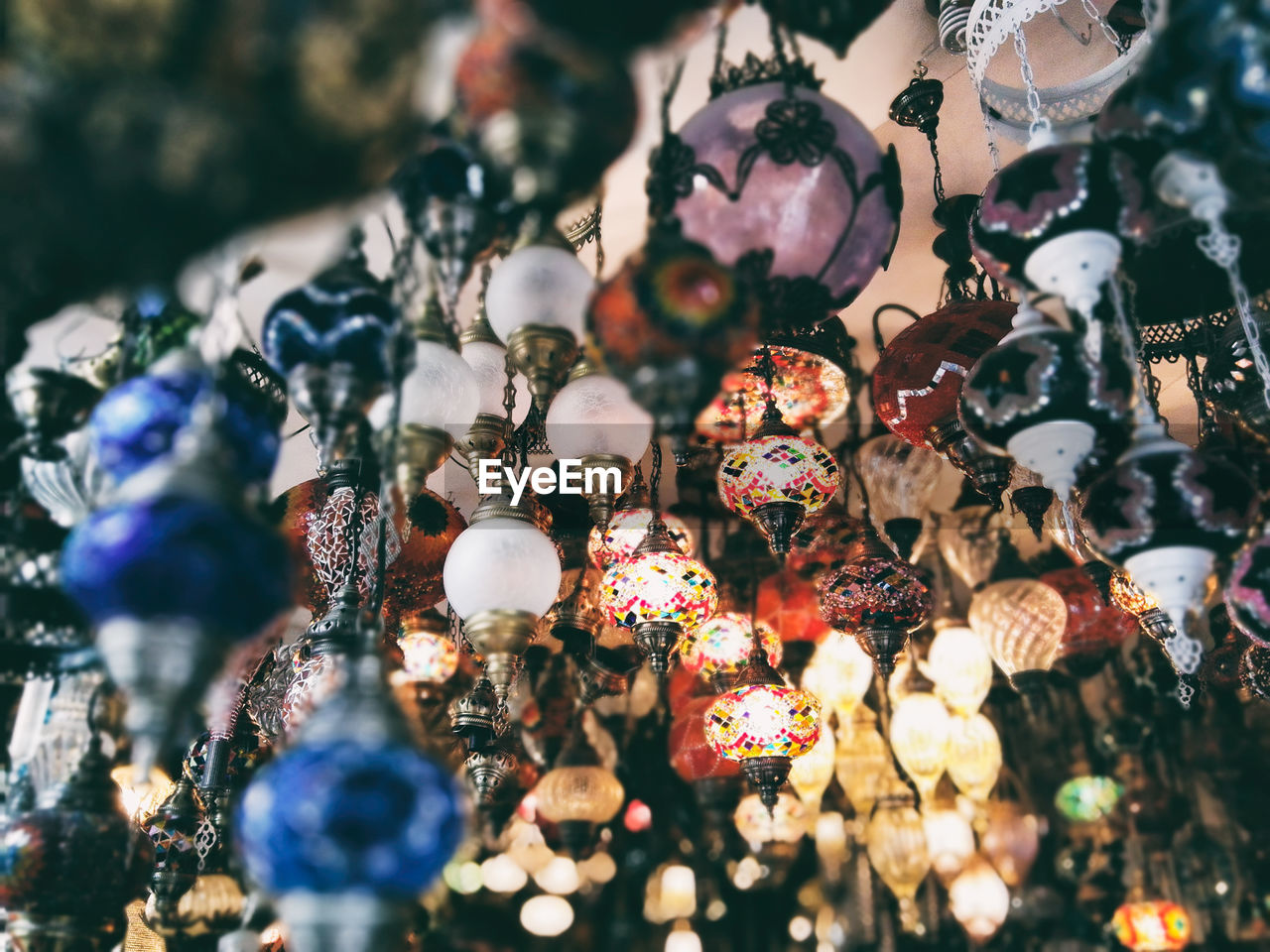 Low angle view of illuminated lighting equipment for sale hanging in store