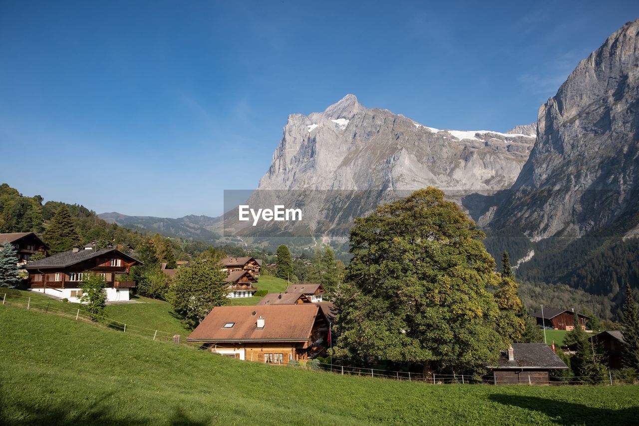 Scenic view of houses and mountains against sky