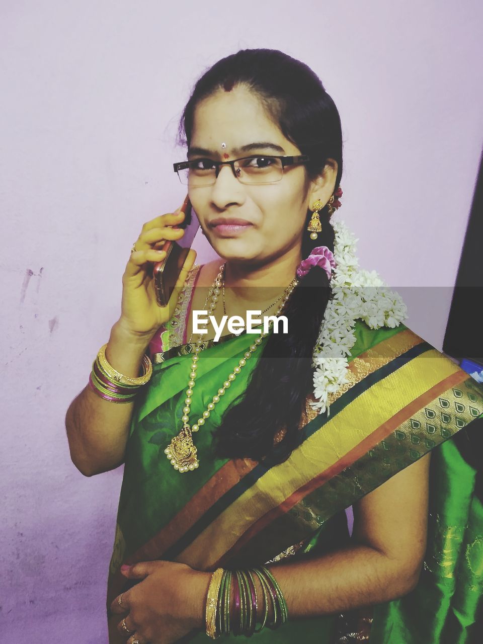 PORTRAIT OF YOUNG WOMAN WEARING EYEGLASSES