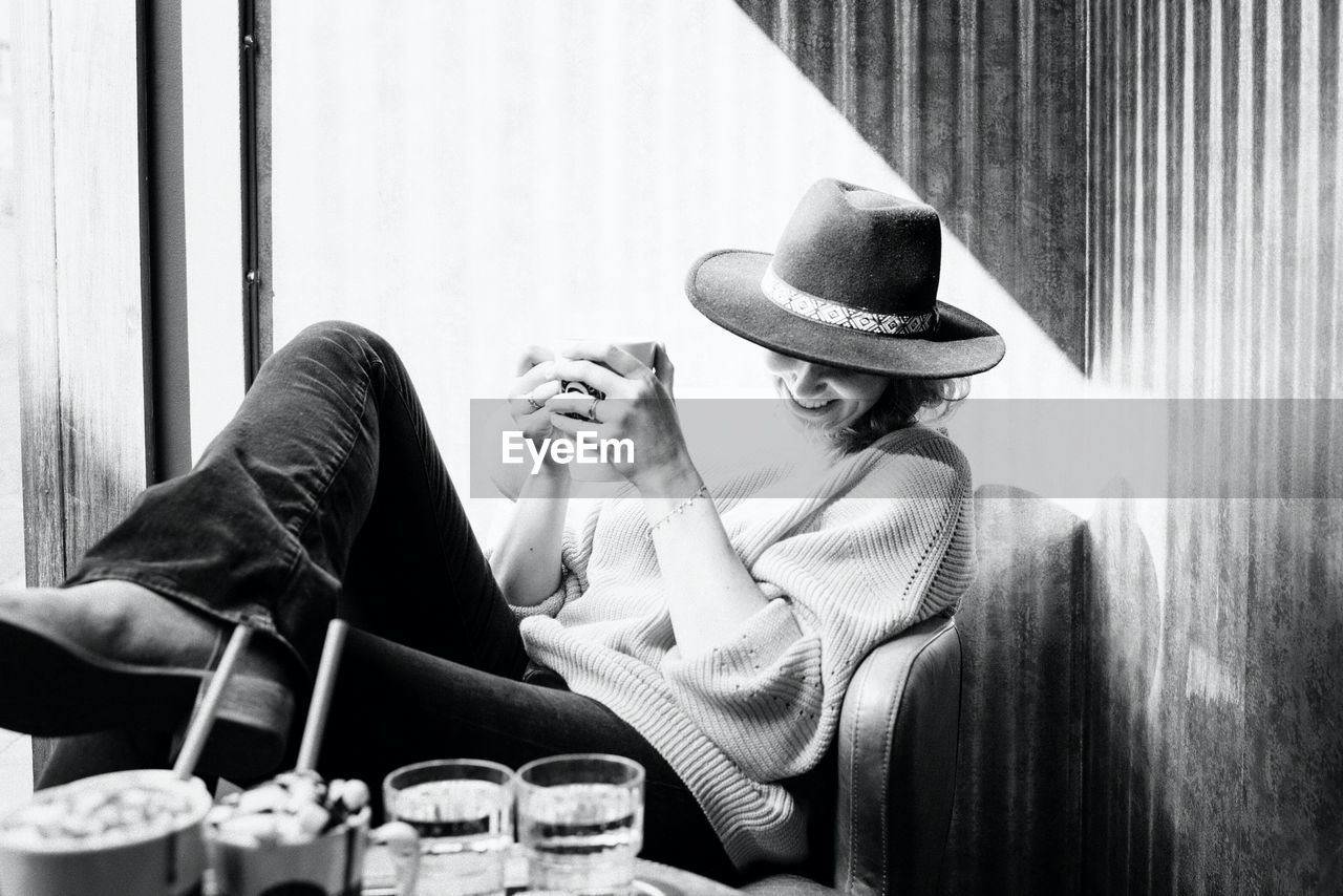 Woman sat smiling drinking coffee in a cafe