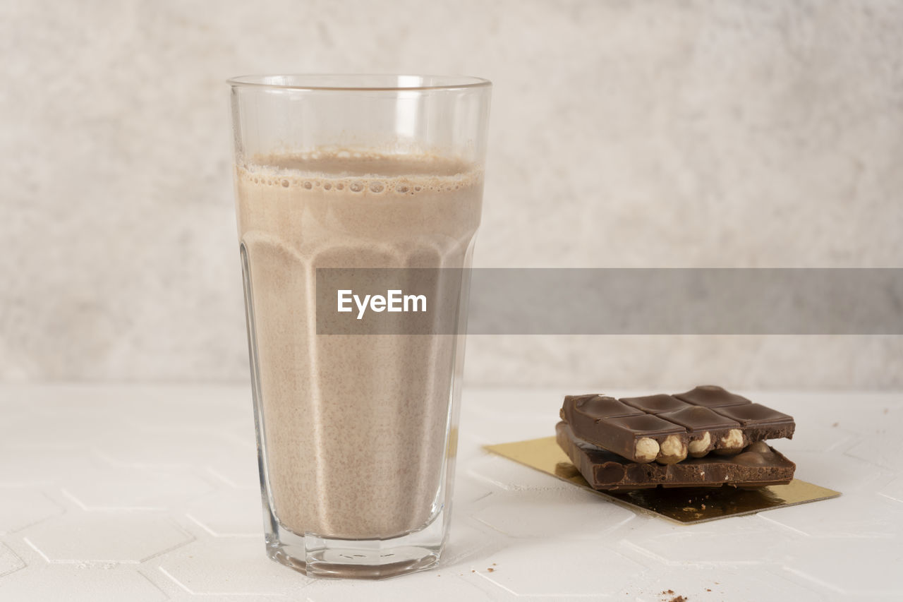 Delicious homemade cocoa drink with milk, cocoa powder and pieces of chocolate bar. close-up.