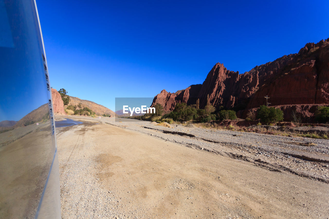 ROAD BY MOUNTAIN AGAINST CLEAR BLUE SKY