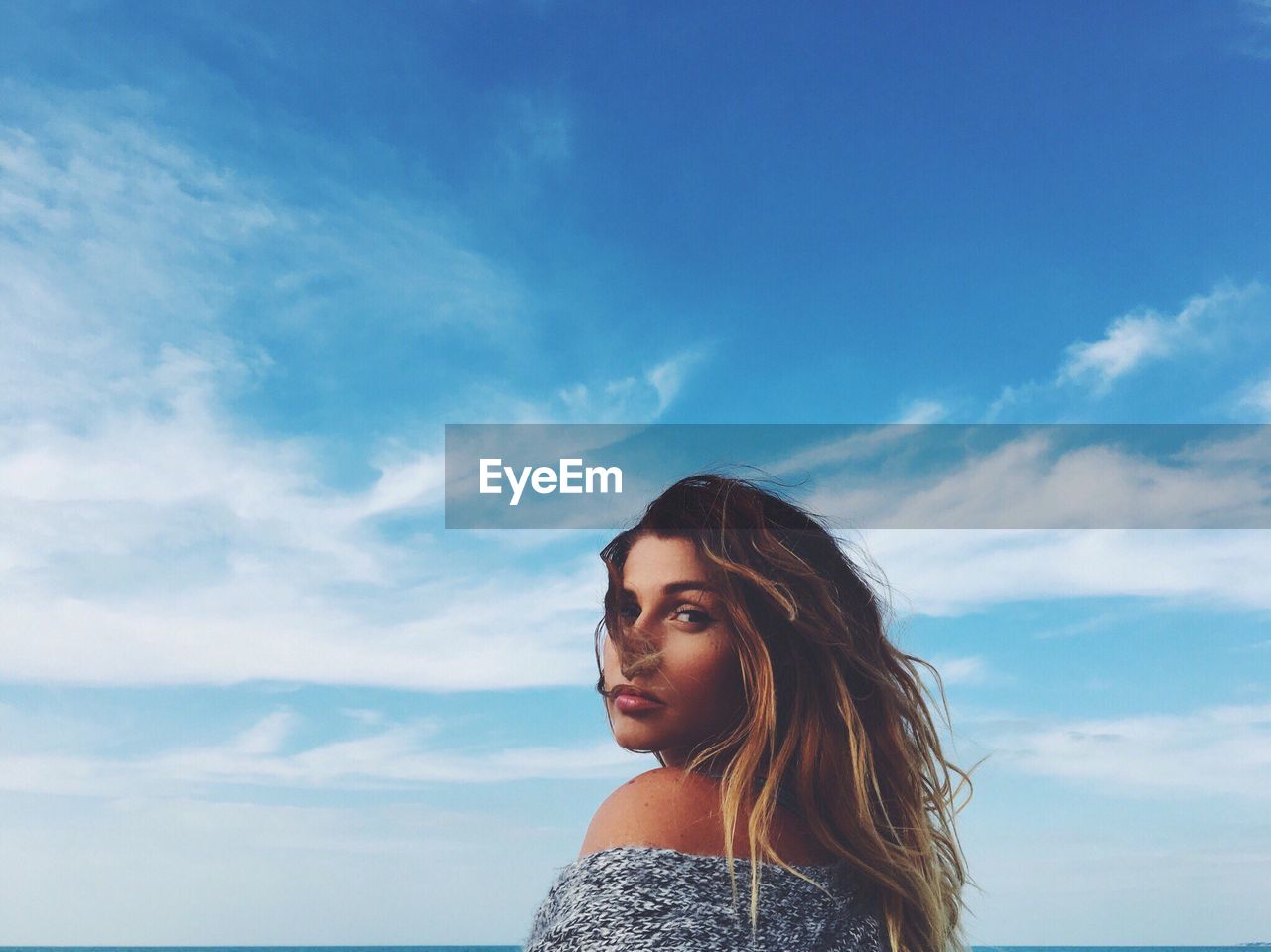 WOMAN AGAINST BLUE SKY