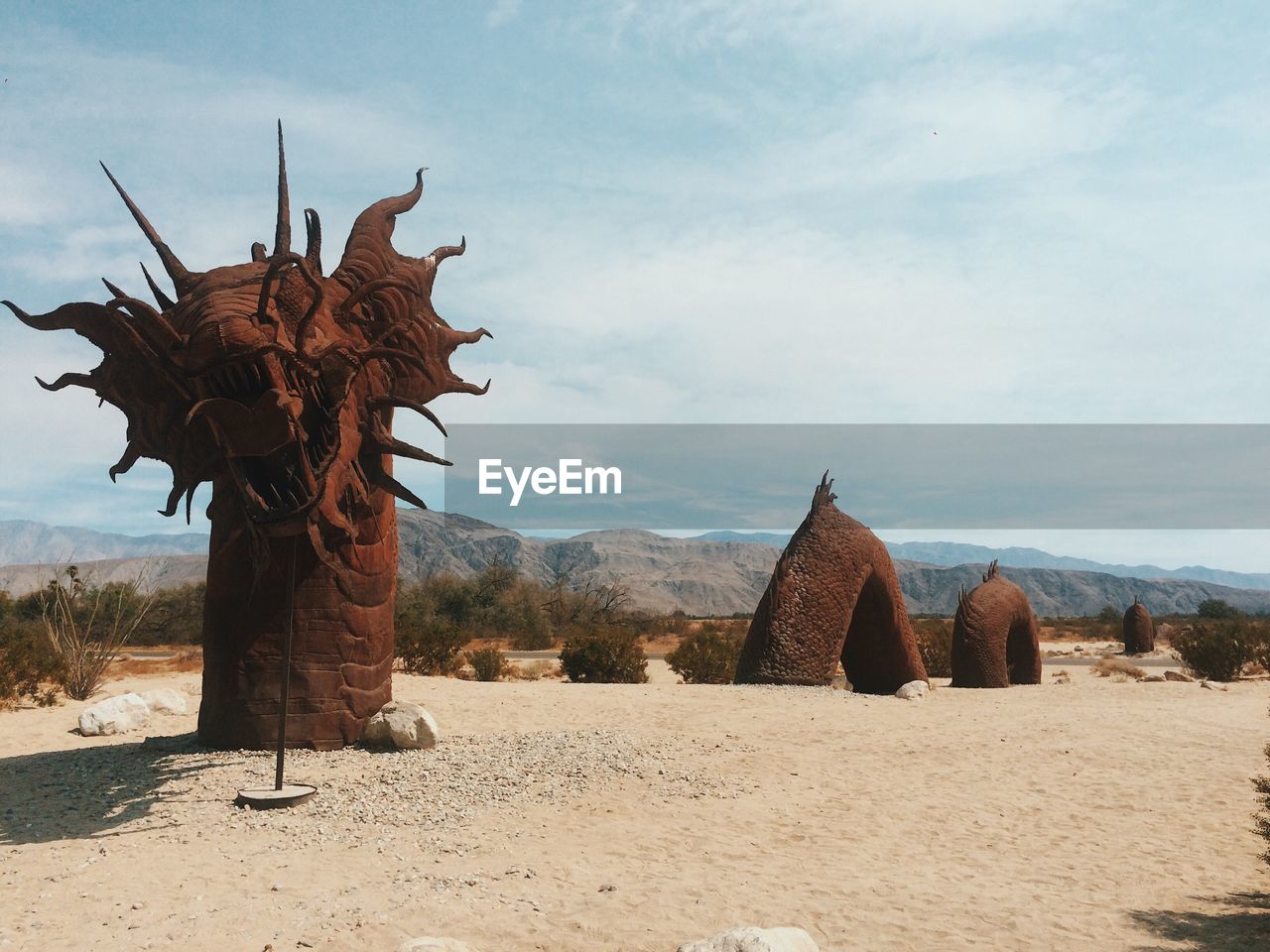 Dragon sculpture at desert against sky