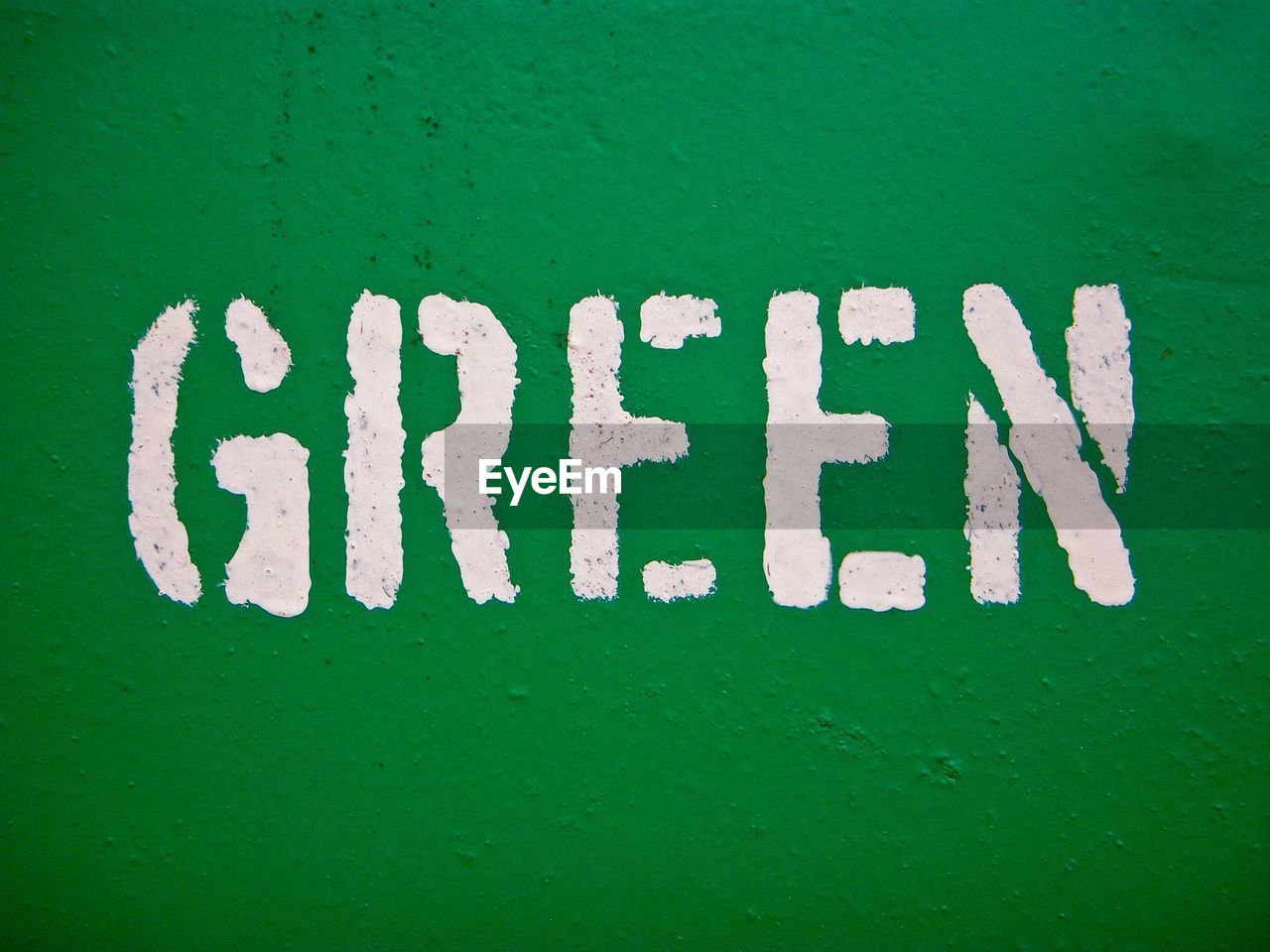 Close-up of text written on green wall