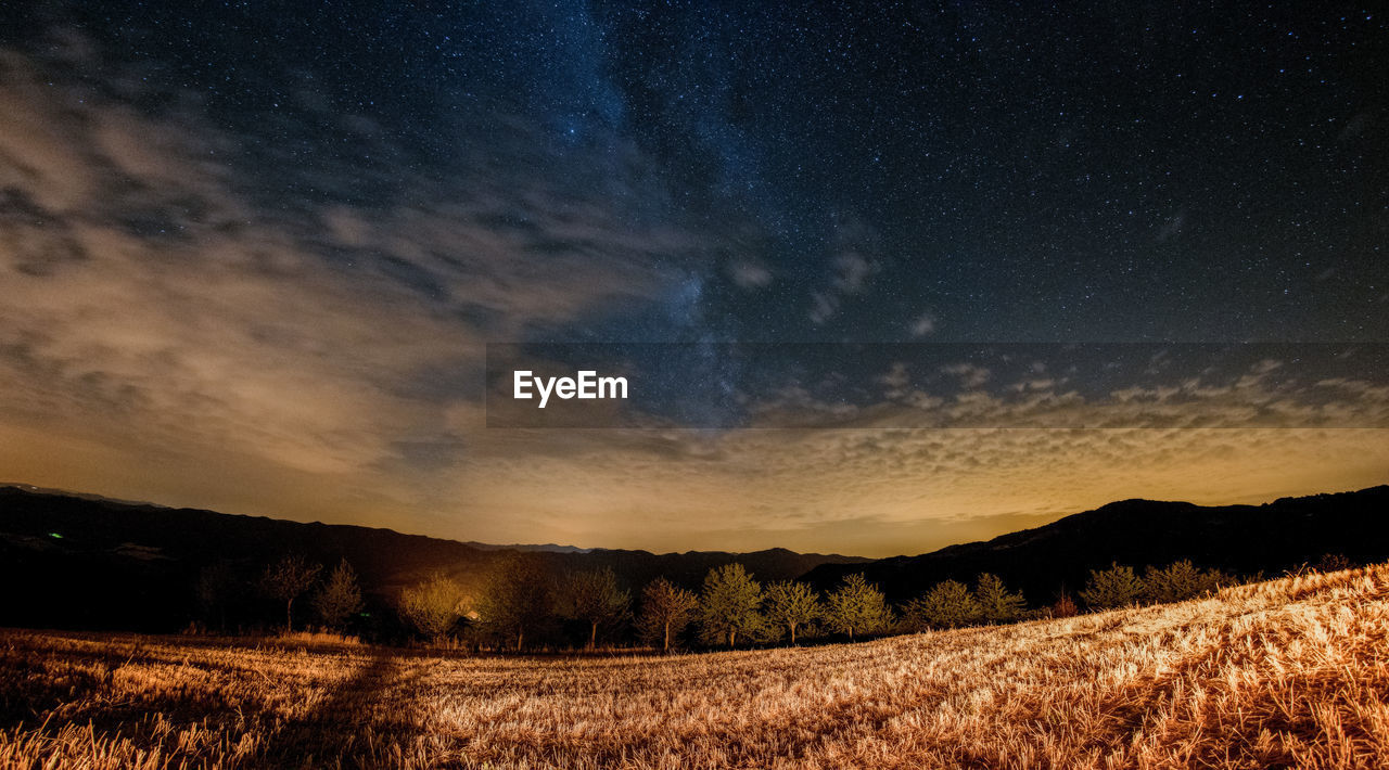 Scenic view of field against sky at night