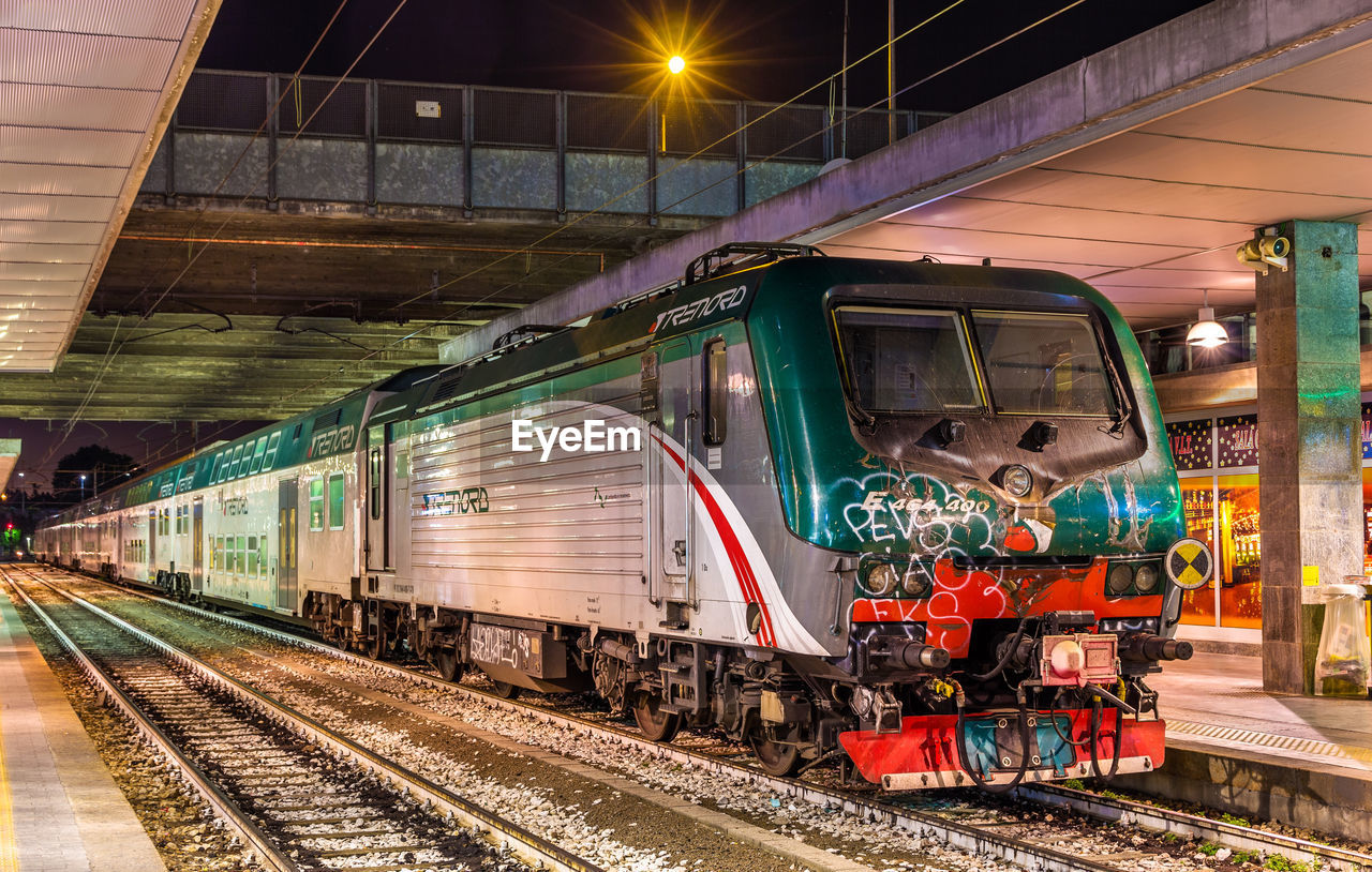 TRAIN IN RAILROAD STATION AT NIGHT