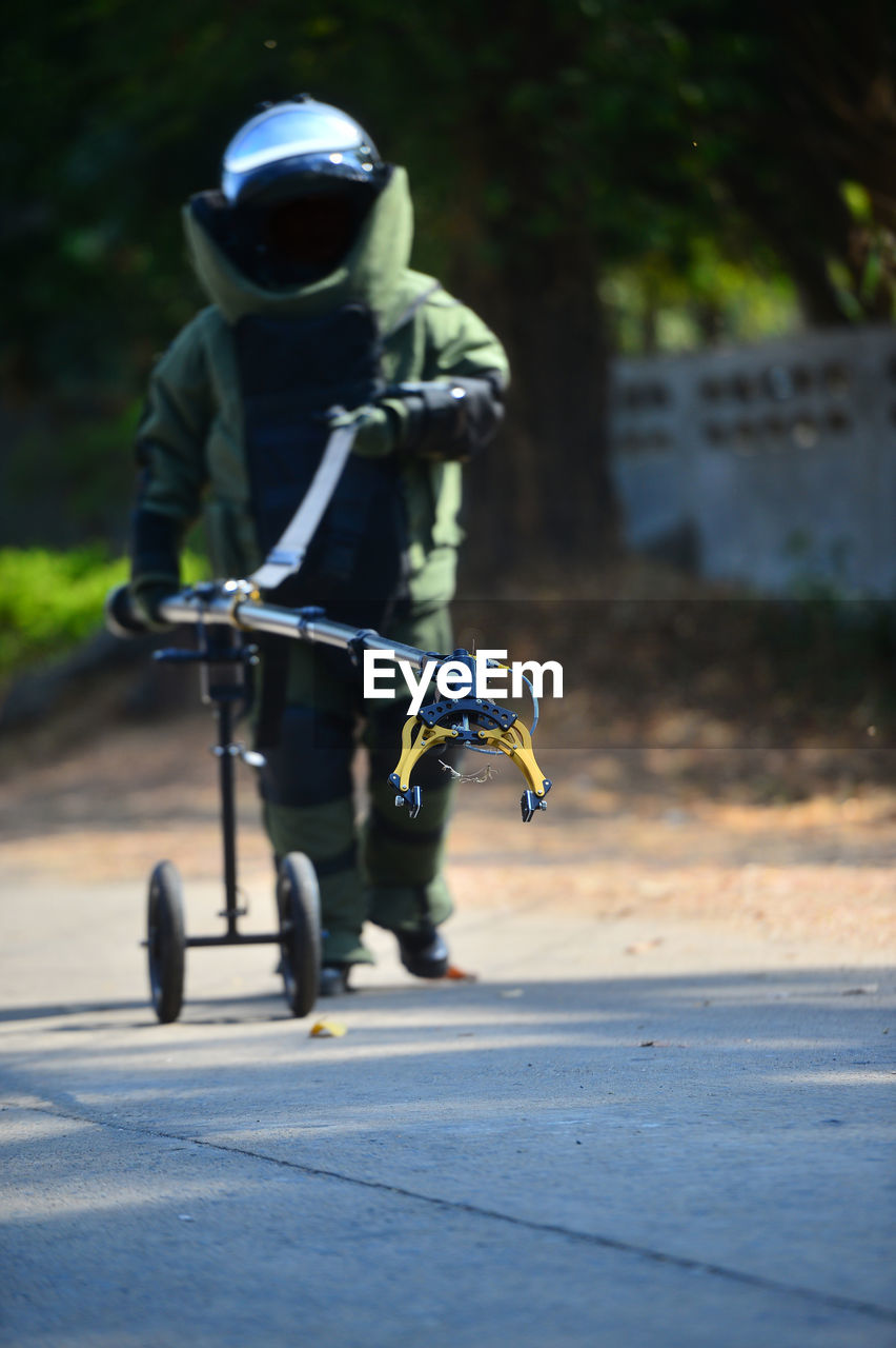 Full length of man wearing protective suit walking on road