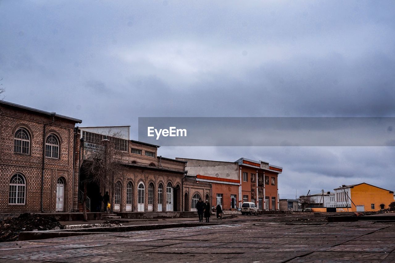 STREET AMIDST OLD BUILDINGS AGAINST SKY