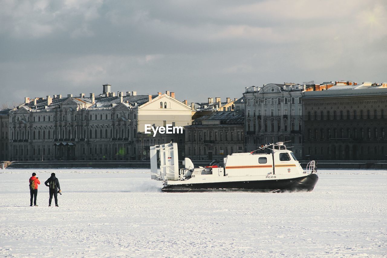 PEOPLE IN FRONT OF BUILDINGS IN WINTER