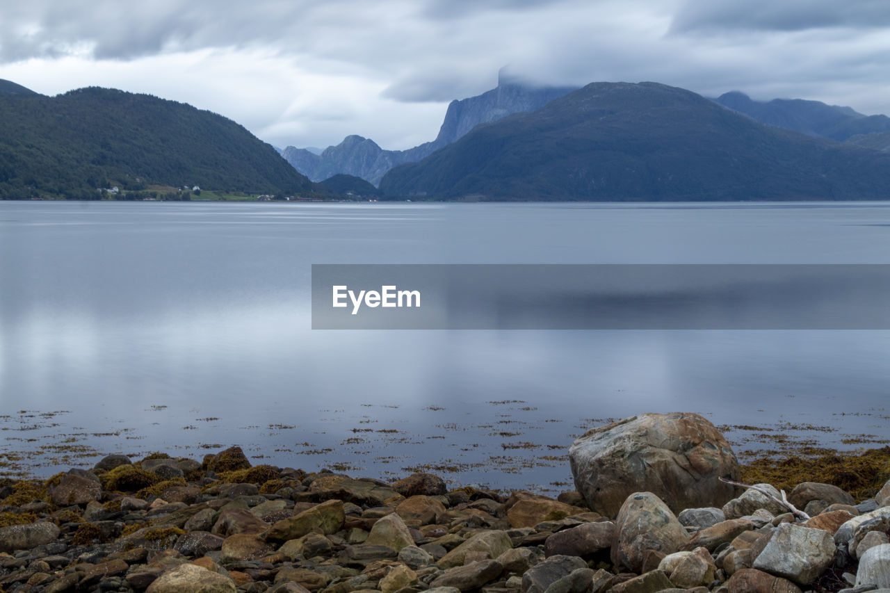 Scenic view of sea and mountains against sky