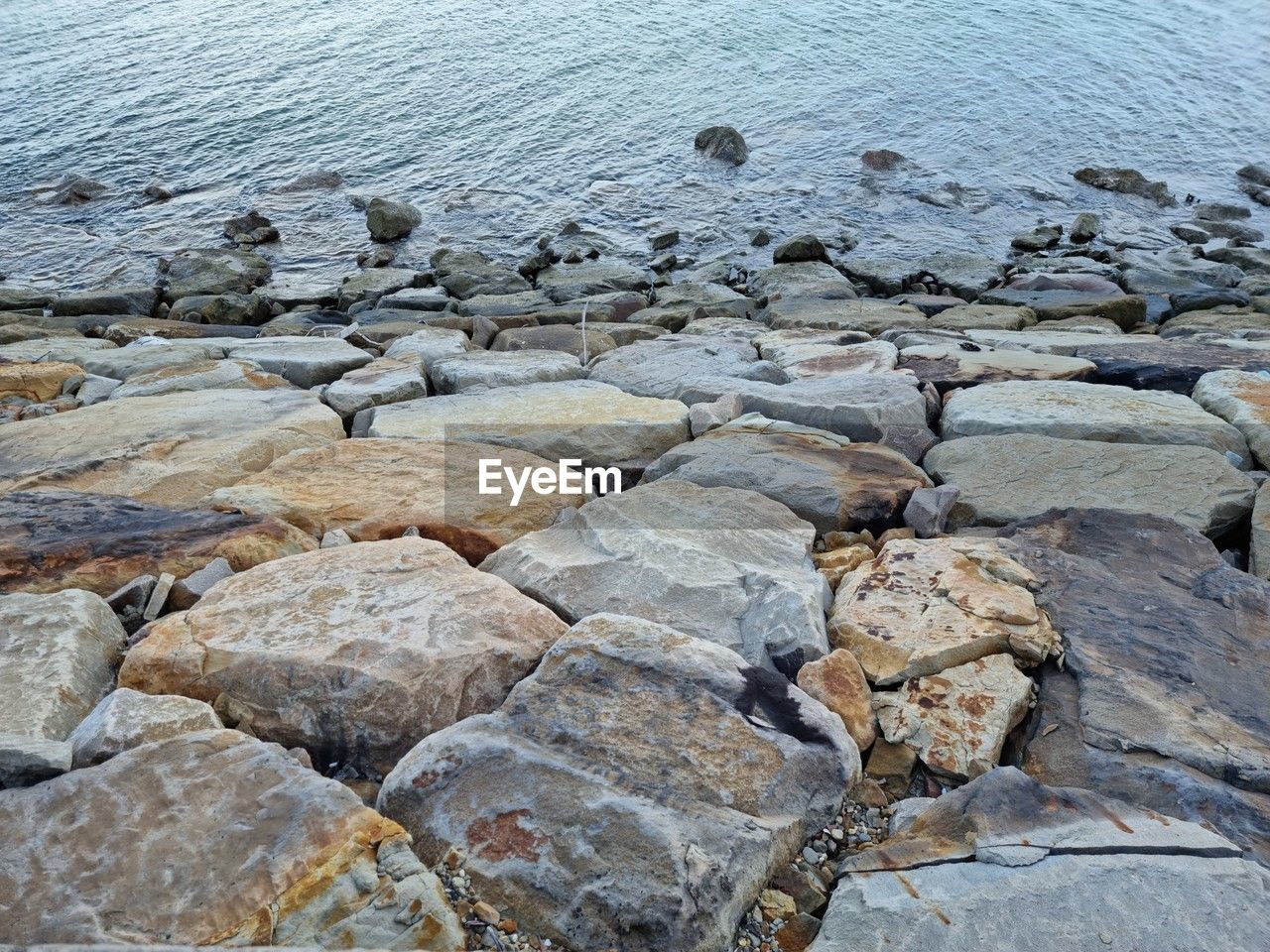 rock, shore, water, nature, sea, day, no people, coast, land, beauty in nature, beach, tranquility, geology, scenics - nature, high angle view, outdoors, tranquil scene, textured, stone, non-urban scene, backgrounds, full frame