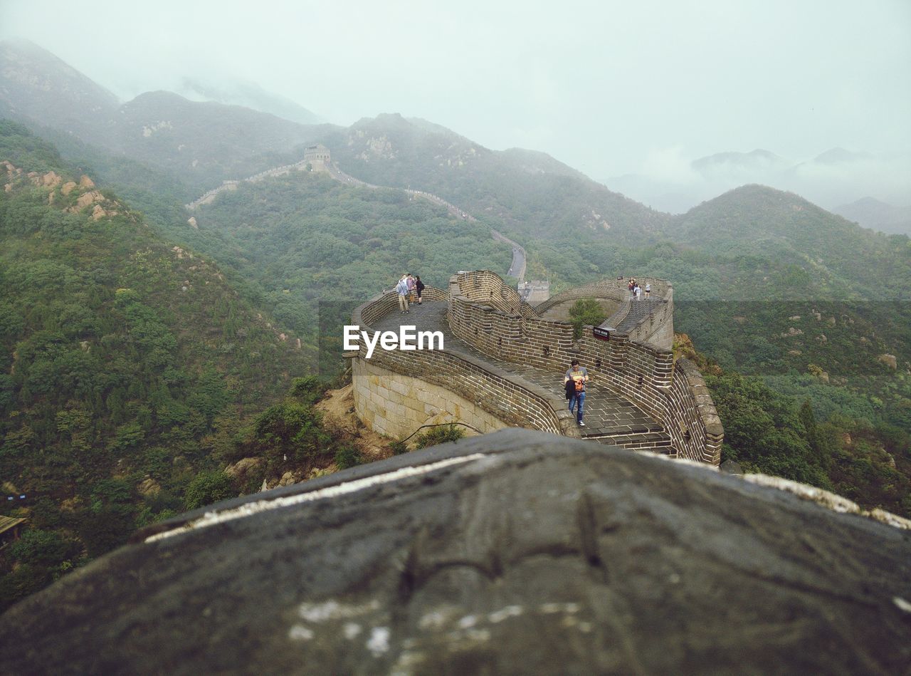 Tourists at great wall of china against sky