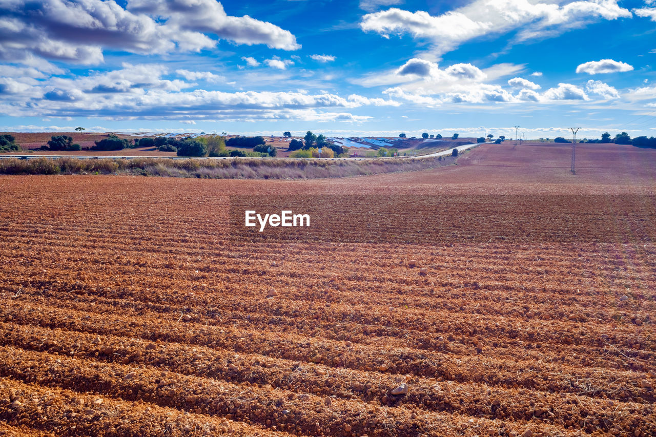 horizon, landscape, environment, sky, land, field, plain, scenics - nature, nature, cloud, natural environment, agriculture, prairie, beauty in nature, soil, grassland, rural scene, no people, steppe, tranquility, tranquil scene, blue, day, plateau, outdoors, travel, travel destinations, sunlight, plant, non-urban scene, desert, rural area, water, sand, farm