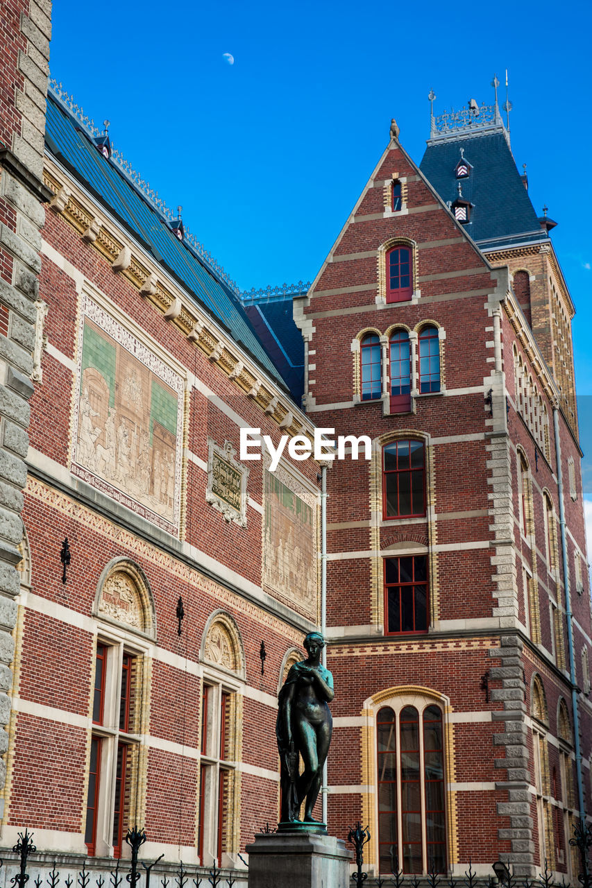 LOW ANGLE VIEW OF STATUE AGAINST BUILDING IN CITY