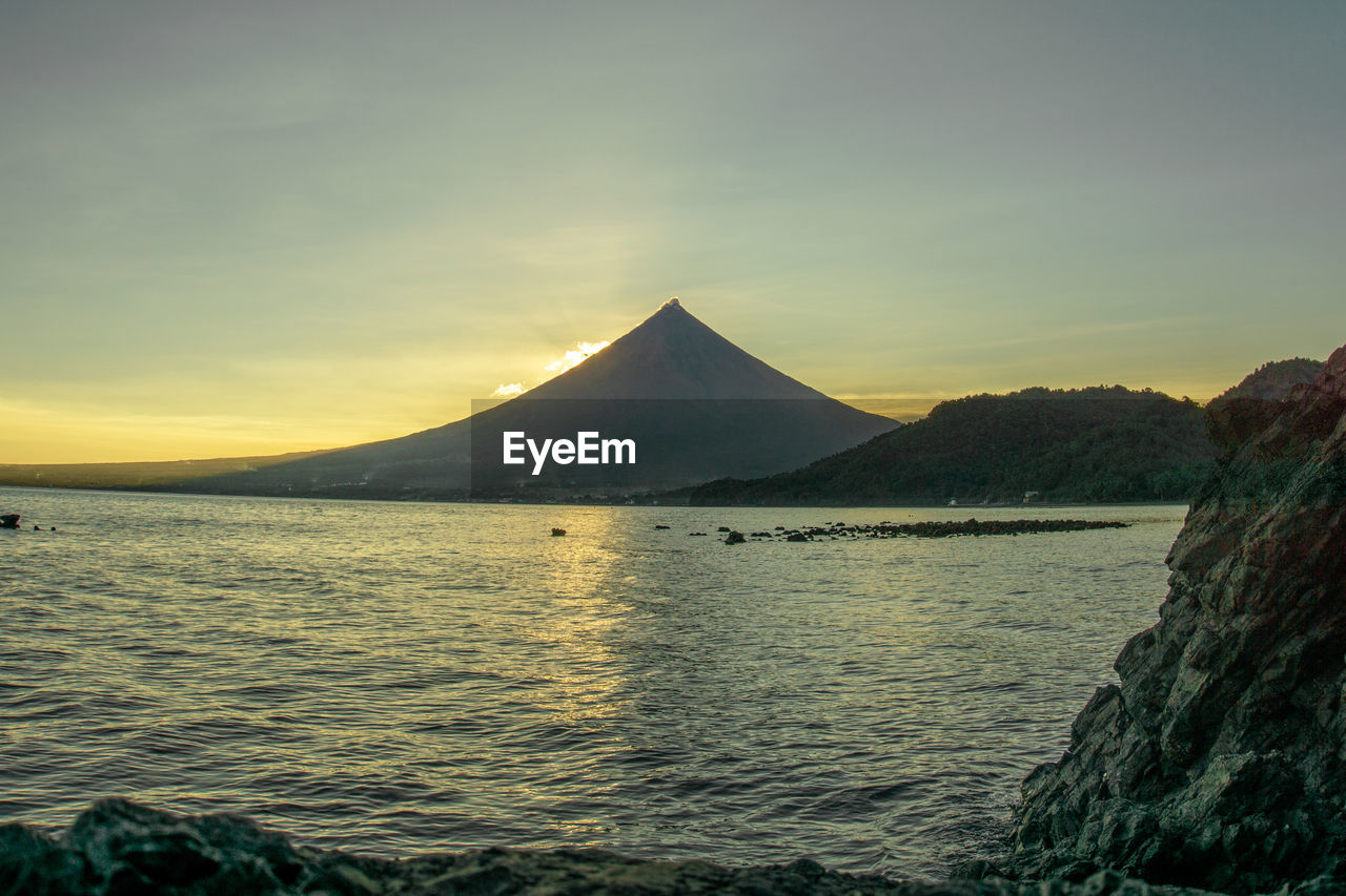 Mayon volcano scenic view of sea against sky during sunset