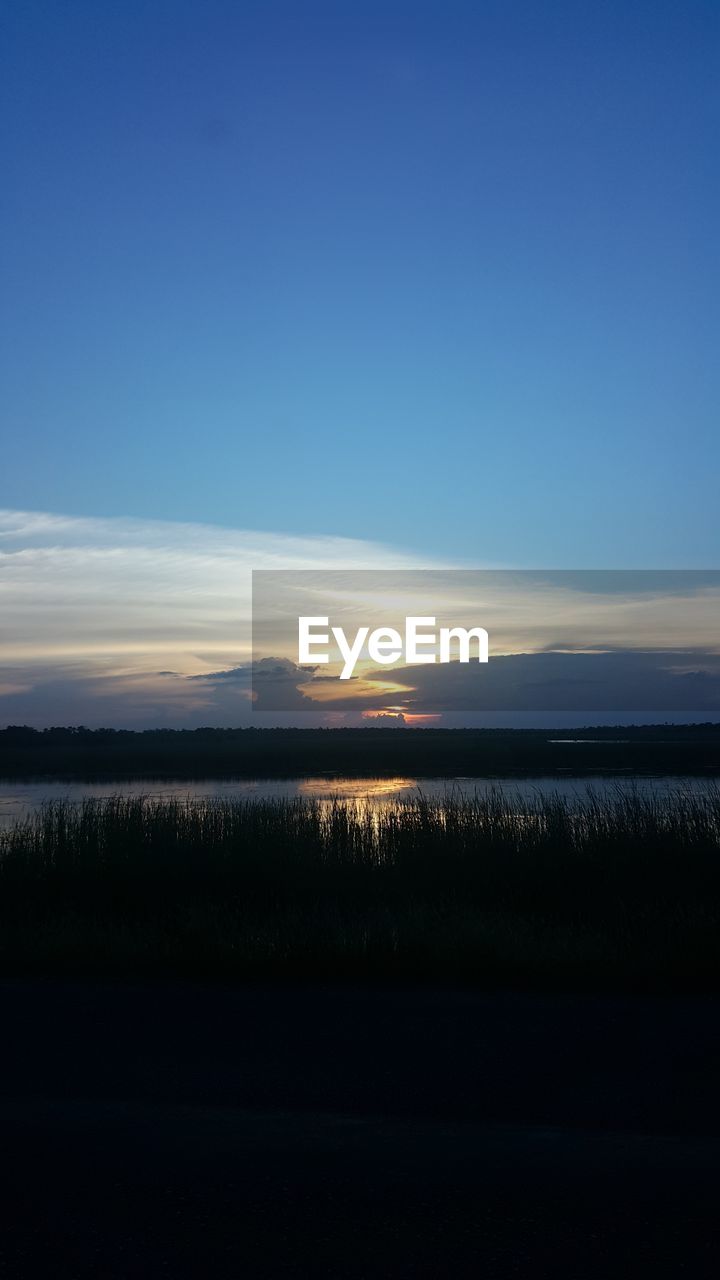 SCENIC VIEW OF LAKE AGAINST SUNSET SKY