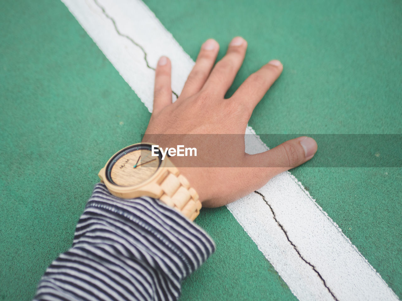 HIGH ANGLE VIEW OF HUMAN HAND ON GREEN