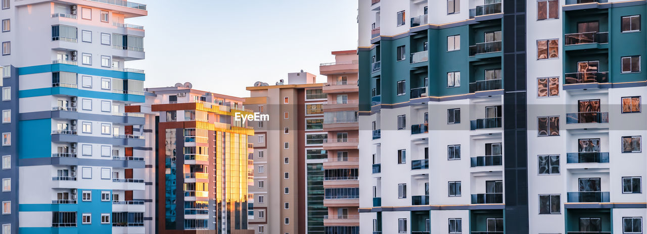 Fragments of facades of modern multi-storey residential buildings, side view, close-up. banner