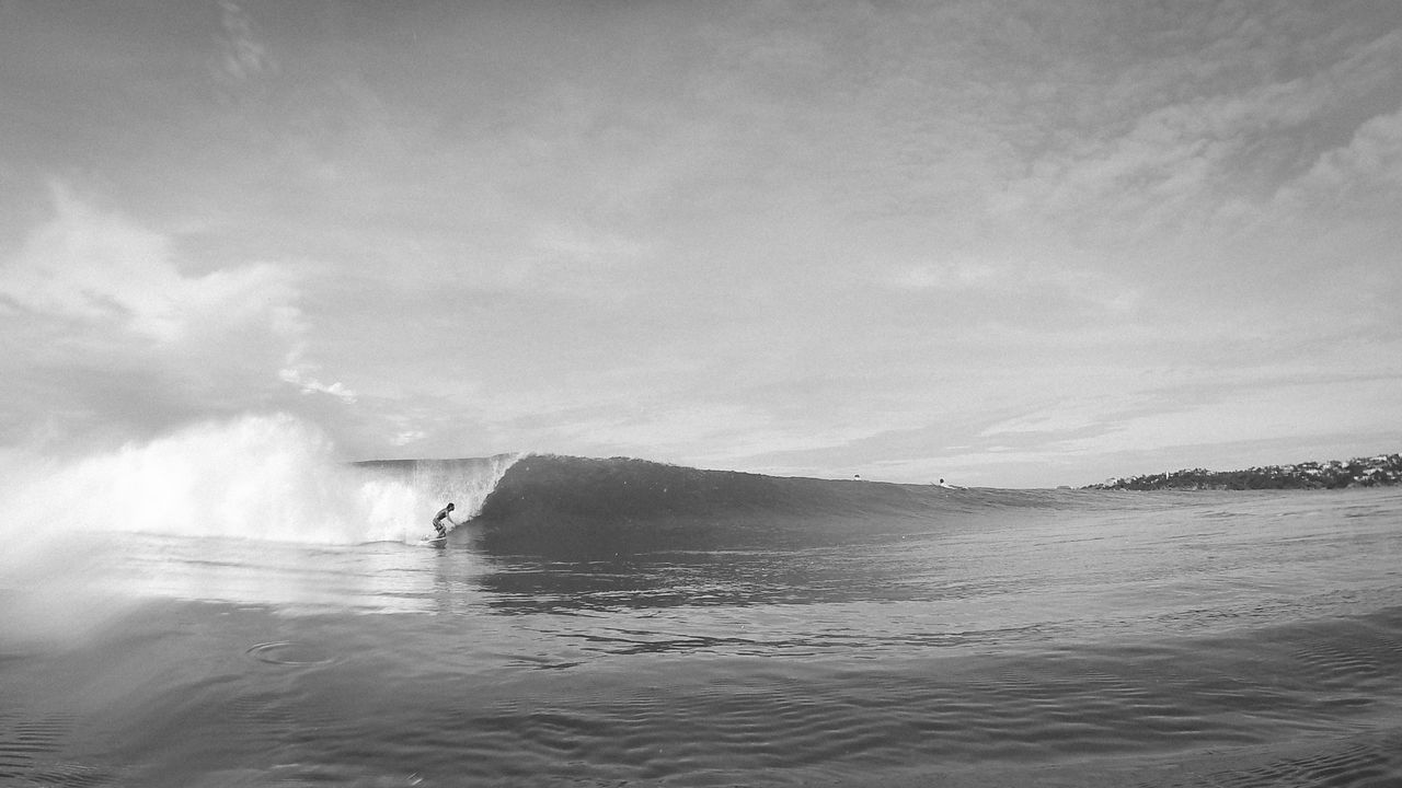 Waves flowing at sea against sky