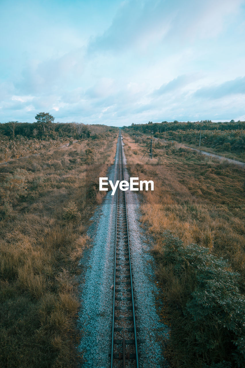 View of railroad tracks on field against sky