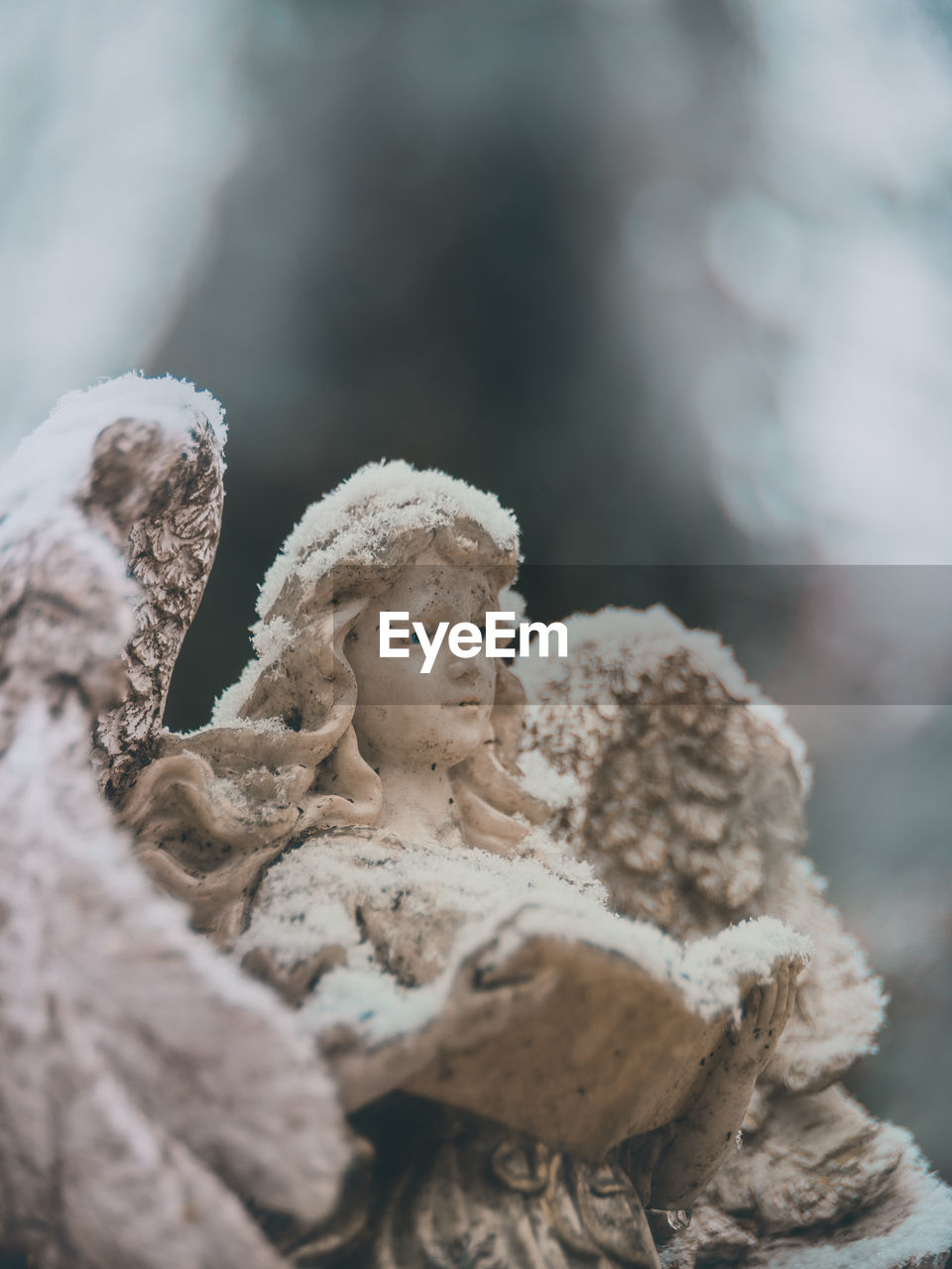 CLOSE-UP OF ANGEL STATUE AGAINST SNOW