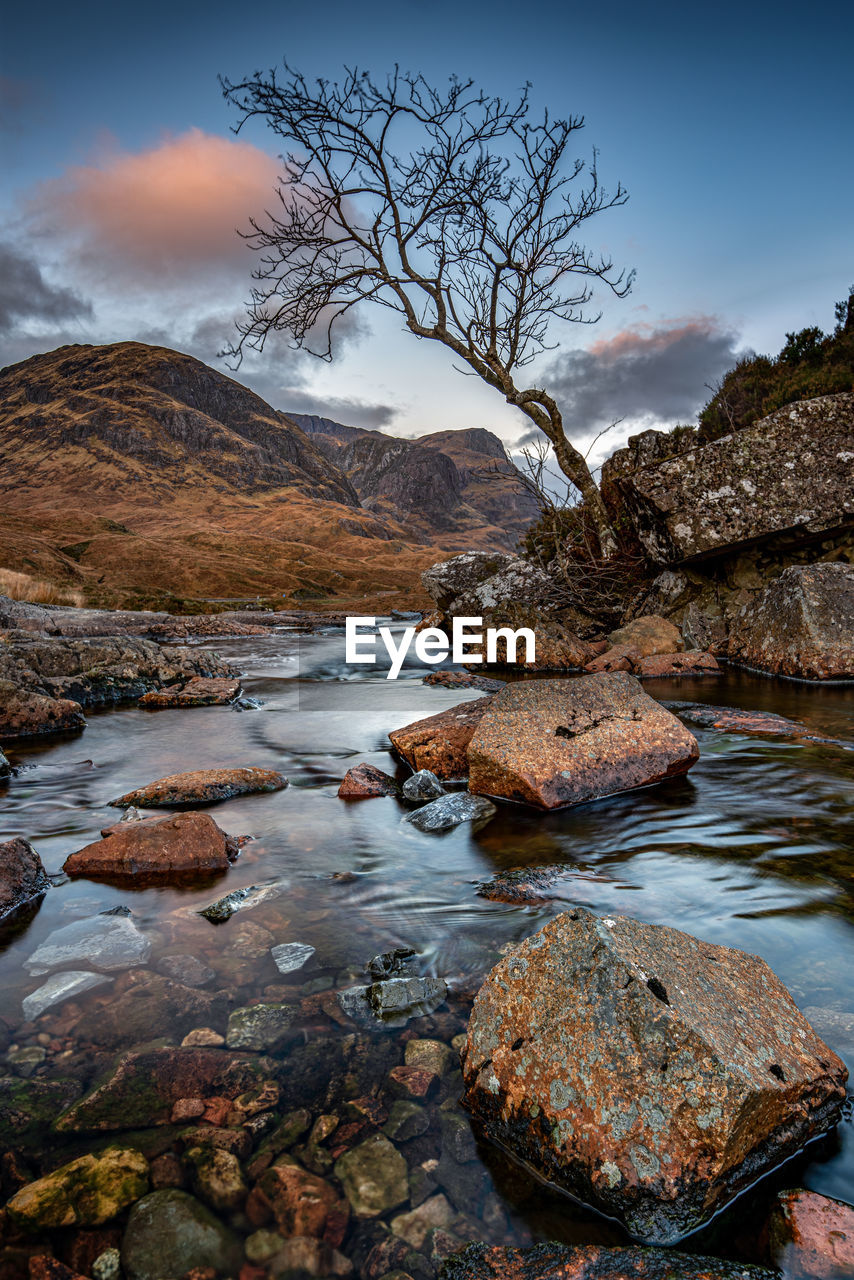 Looking down through glen coe to the mountains known as the three sisters after a winter sunset