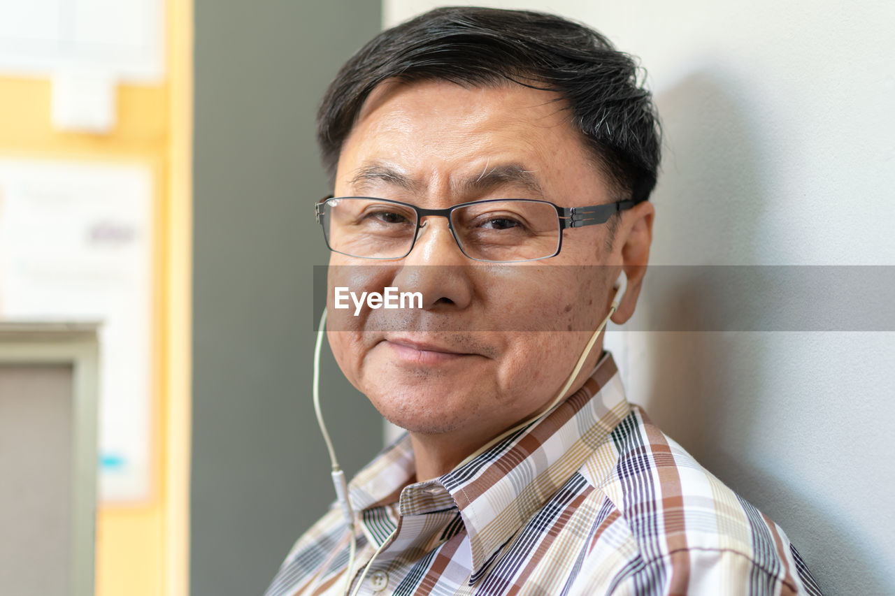 Close-up portrait of senior man listening to music