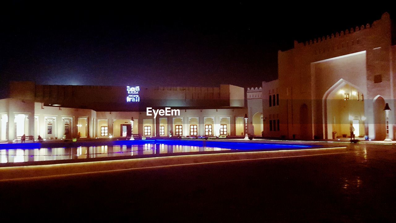 ILLUMINATED BUILDINGS IN CITY AT NIGHT