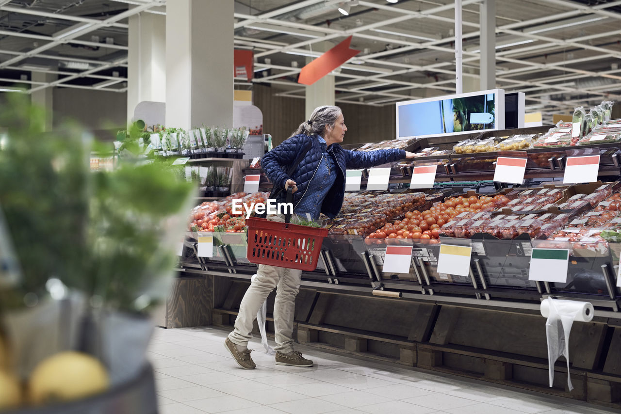 Woman buying vegetables from supermarket