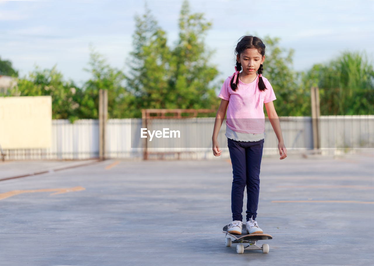 Full length of girl skateboarding at park