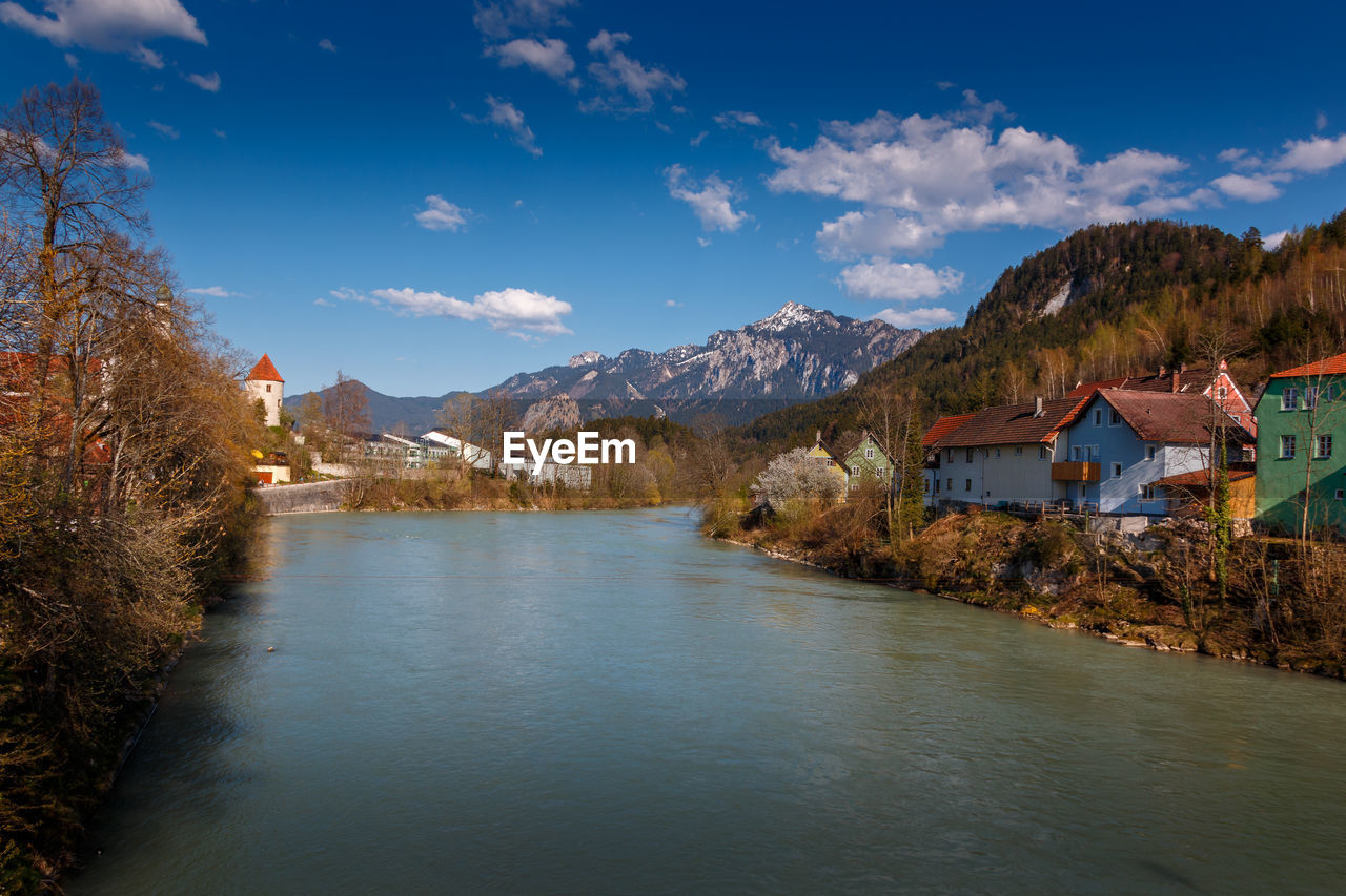 Scenic view of lake by buildings against sky