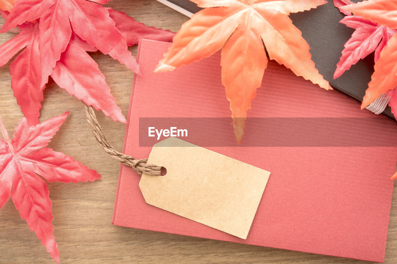 High angle view of label with envelope and maple leaves on table