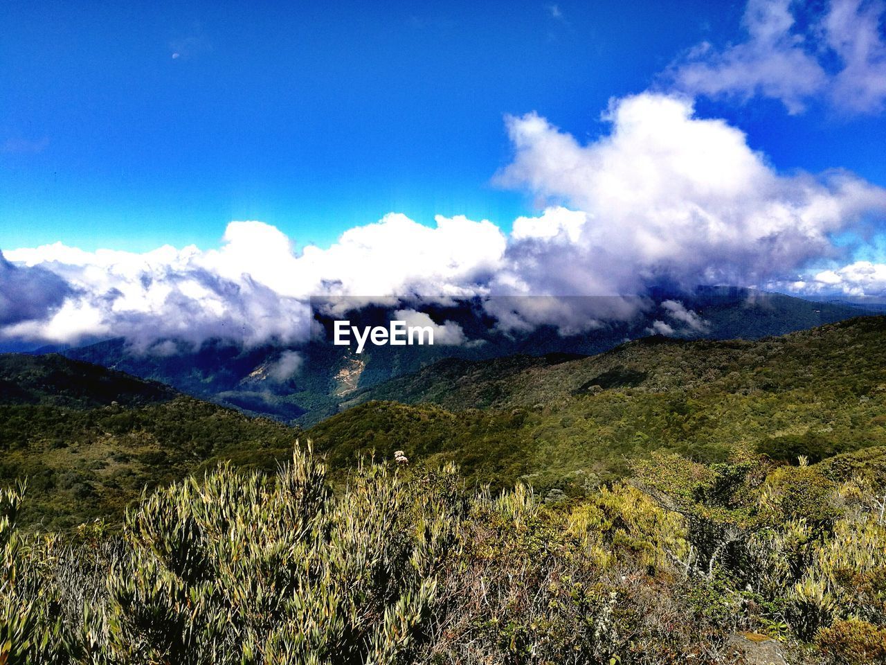 Scenic view of mountains against blue sky