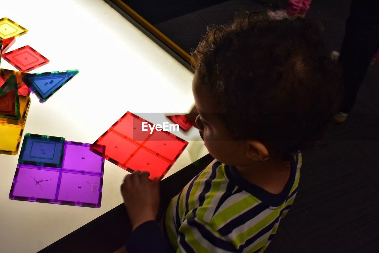 side view of girl playing with toy blocks